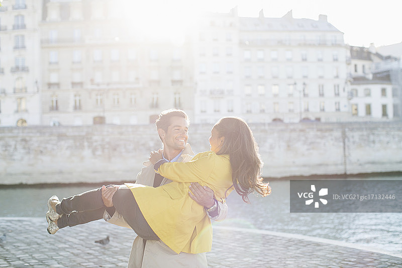 法国巴黎，一名男子在塞纳河边抱着女友图片素材
