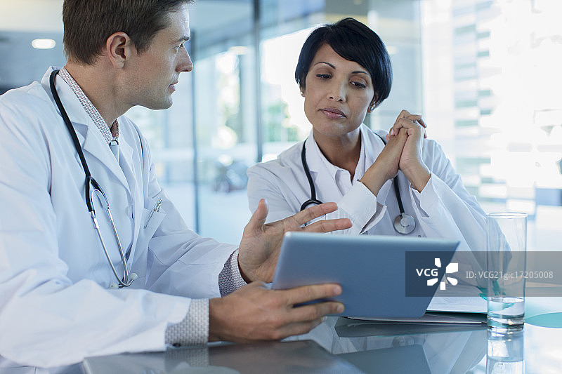 医生们使用平板电脑在桌前讨论病人的治疗方法图片素材