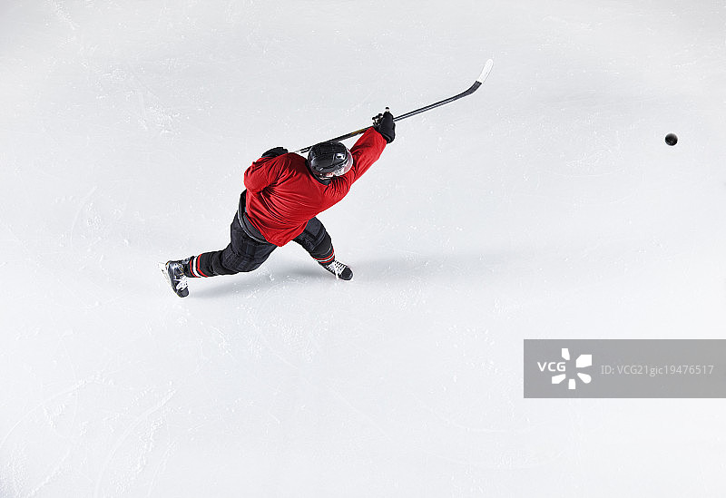 穿着红色制服的曲棍球运动员在冰上打冰球图片素材