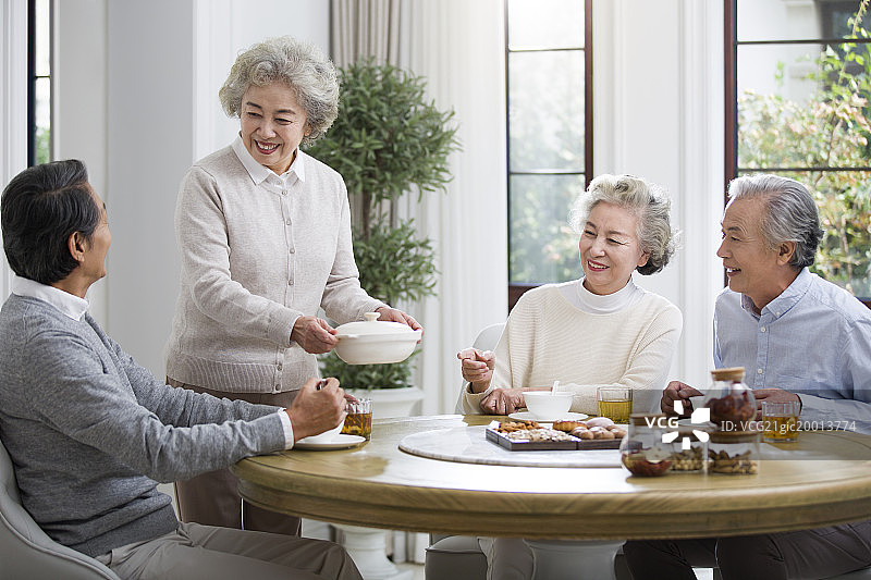 快乐的老年人聚在一起吃饭图片素材