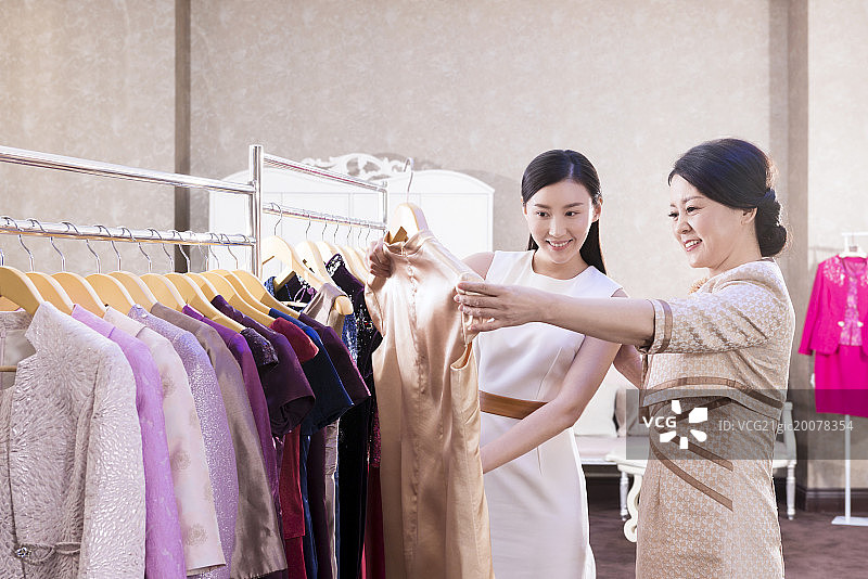 Designer helping customer choosing gown图片素材