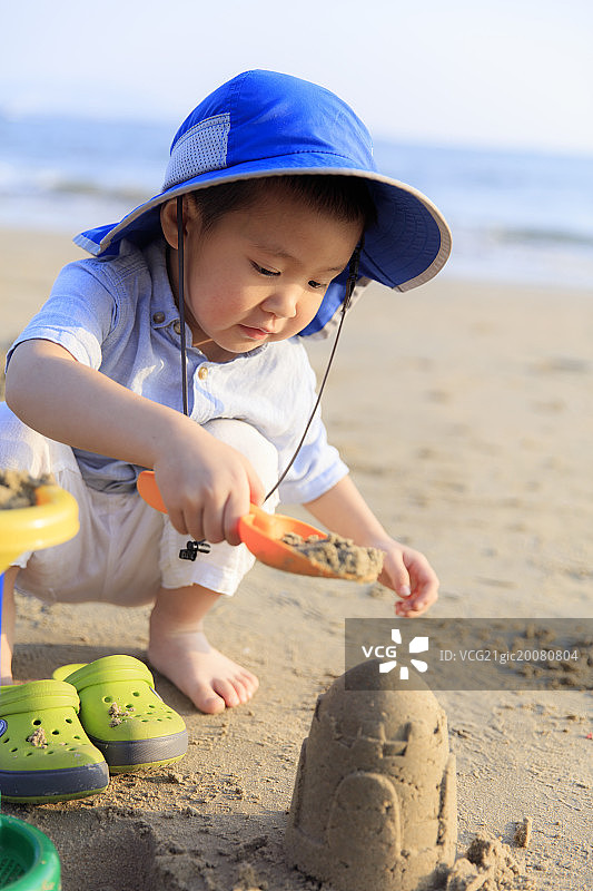 海滩玩沙子的小男孩图片素材