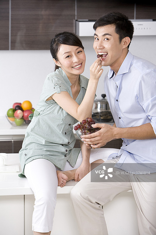 青年夫妇在厨房吃葡萄图片素材