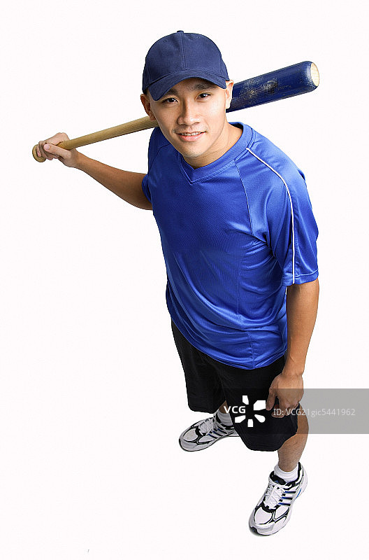 一个年轻人拿着棒球棒，对着镜头微笑图片素材