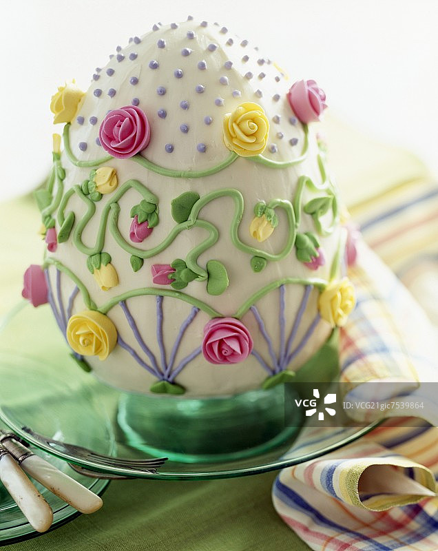 盘子上的复活节鸡蛋蛋糕，上面有糖霜玫瑰装饰图片素材