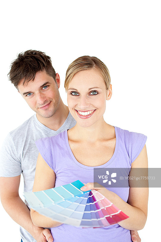 一对深情的年轻夫妇在为新房子里的房间选择颜色图片素材