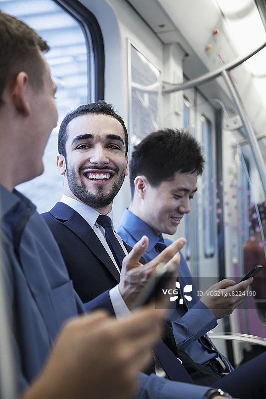 三个商人在地铁里坐成一排聊天图片素材