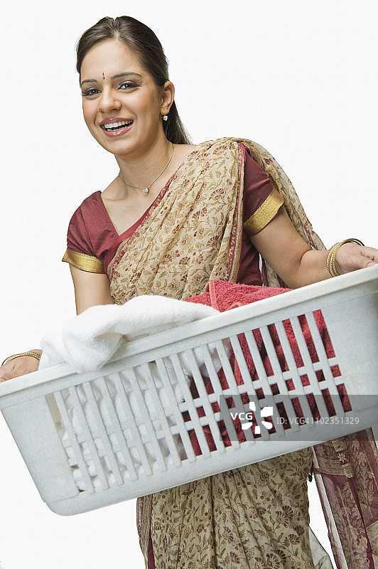 女人提着洗衣篮，面带微笑图片素材