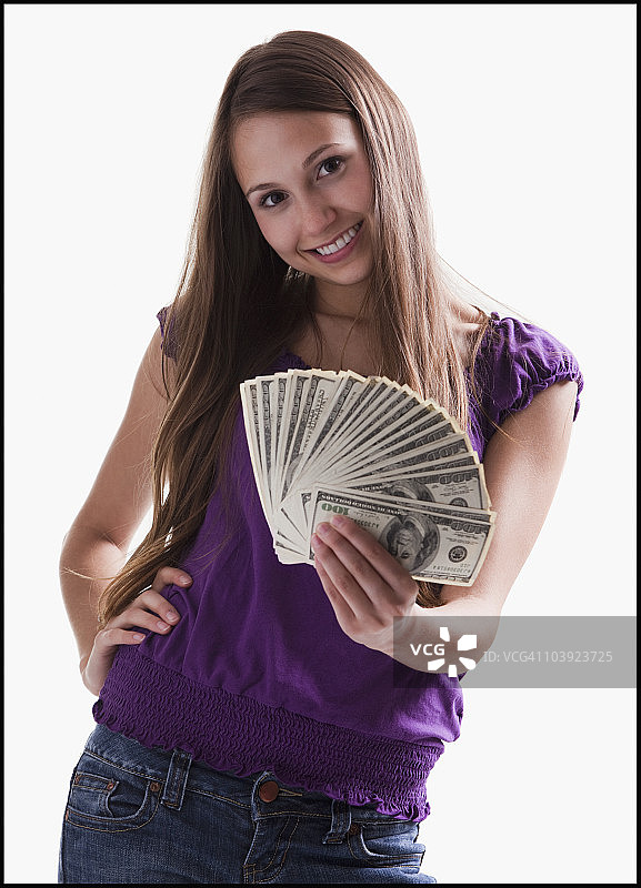 十几岁的女孩手里拿着几张百元大钞图片素材