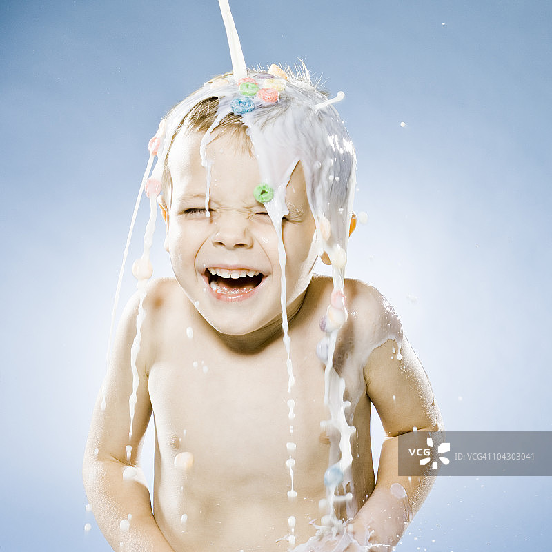 男孩的麦片和牛奶被倒在他的头上图片素材