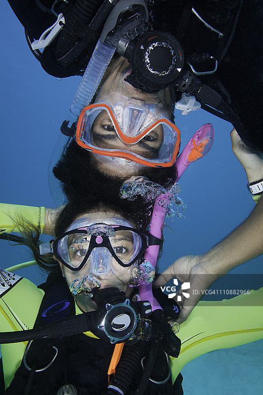 一对潜水员夫妇在水下玩耍。图片素材