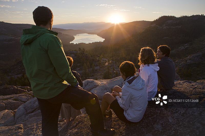 一群朋友在山上看日出。图片素材