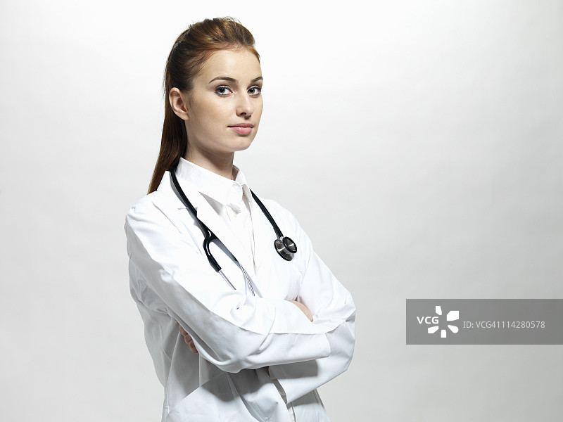 一个女医生微笑着双臂交叉的特写图片素材