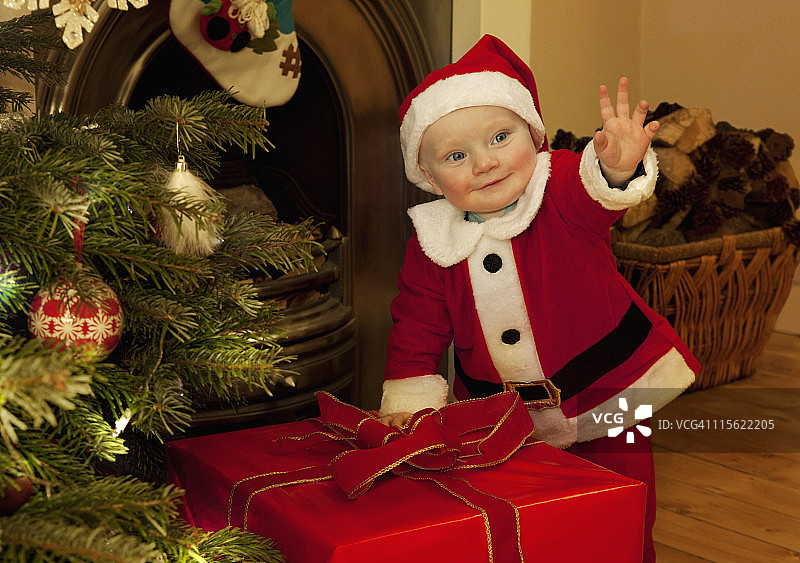 圣诞老人宝宝站在礼物旁边图片素材