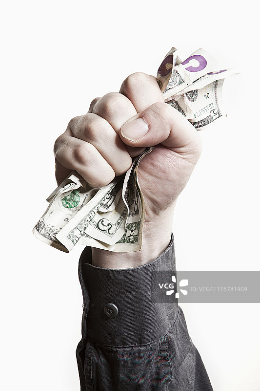 一名男子紧握着一叠美国纸币，特写镜头图片素材
