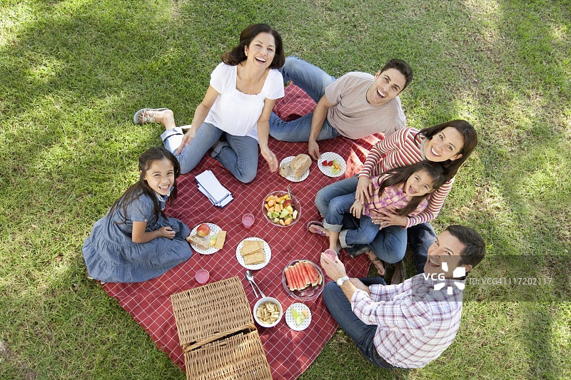 一家人和两个女孩(7-9,10-12)在公园野餐图片素材