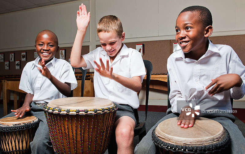 南非豪登省约翰内斯堡的教室里，三个男孩在打鼓图片素材