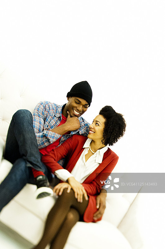 一对情侣在沙发上互相微笑图片素材