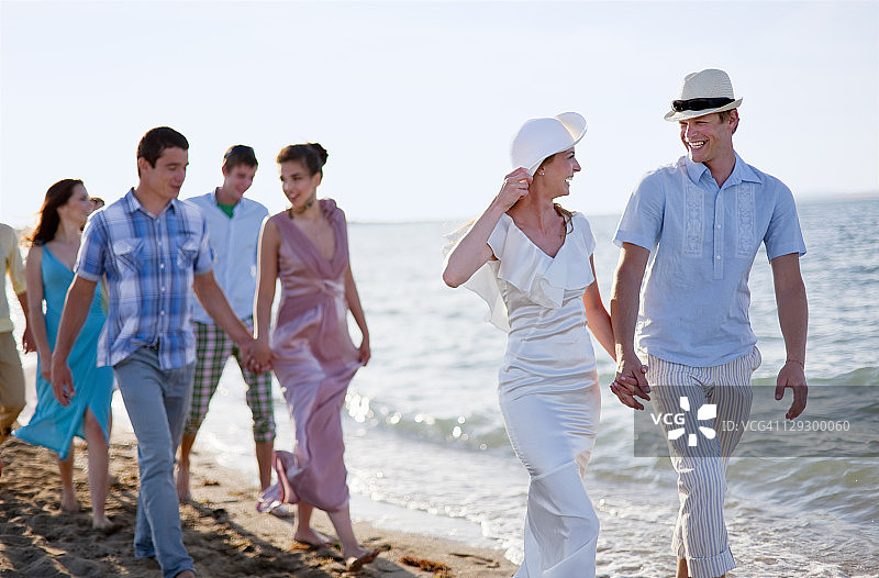 新婚夫妇和朋友在海滩上图片素材