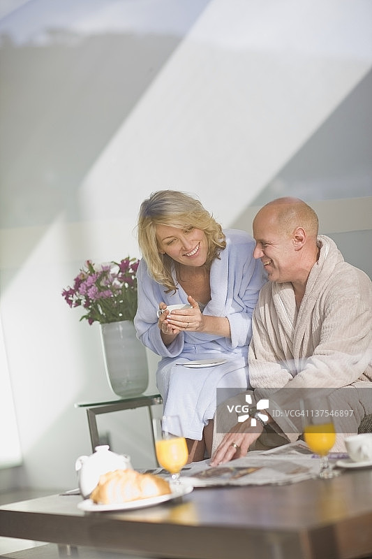 一对穿着浴袍的情侣在吃早餐图片素材