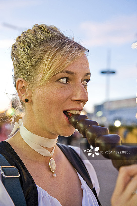 德国巴伐利亚州慕尼黑，一名女子在啤酒节上吃糖果图片素材