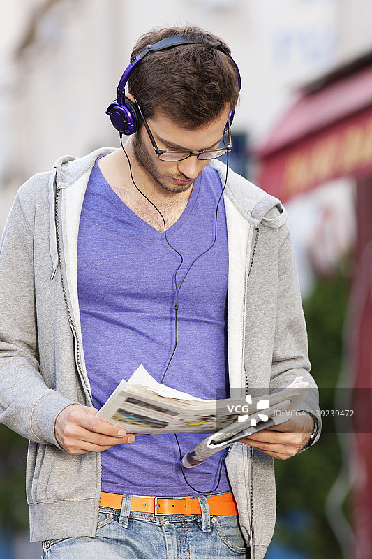 一名男子一边看报纸一边听音乐，巴黎，法兰西岛，法国图片素材