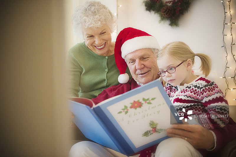 爷爷奶奶给孩子读圣诞书图片素材