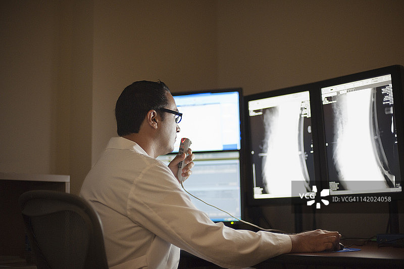 放射科医生检查X光片并记录报告图片素材