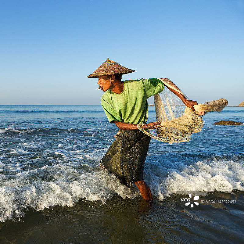 缅甸渔民在Ngapali海滩上撒网图片素材