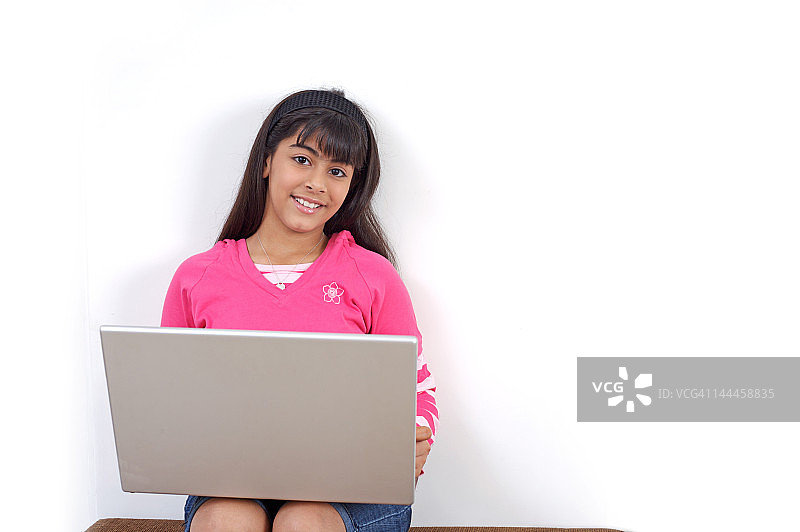 年轻女孩在用笔记本电脑工作图片素材