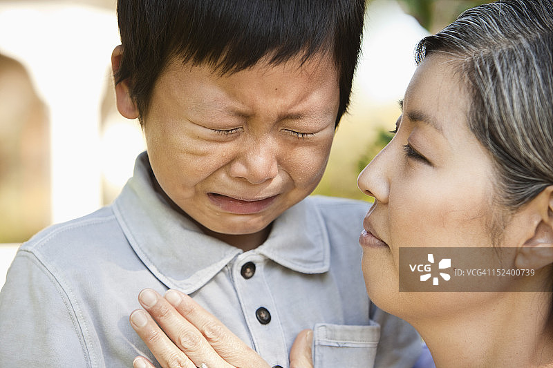 亚洲母亲安慰哭泣的儿子图片素材