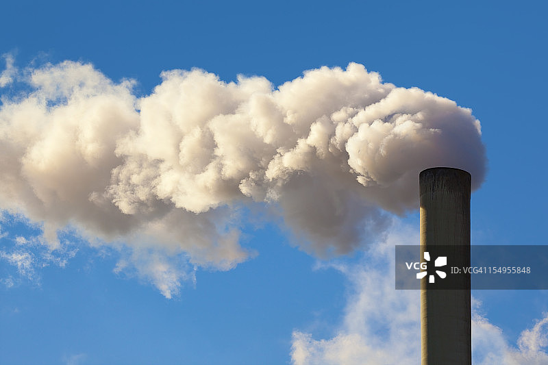 工厂的烟囱向空气中翻腾着肮脏的污染物，蓝天图片素材