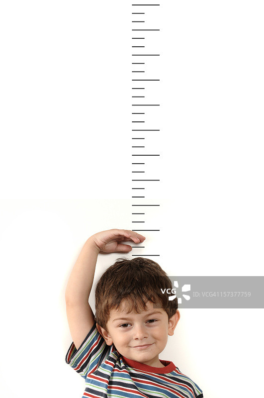 小男孩在测量他的身高图片素材