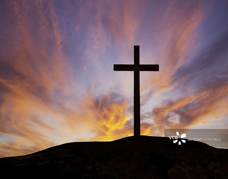 日落时分，山上一个木制十字架的剪影图片素材