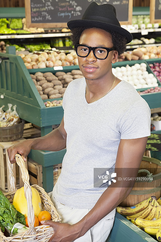 一个非裔美国人在超市拿着菜篮的肖像图片素材