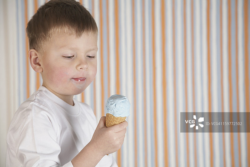 小男孩在吃冰淇淋蛋卷。图片素材