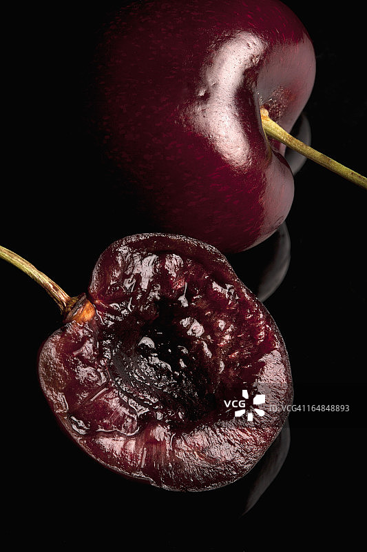 半颗冰樱桃和一颗完整的樱桃放在一起图片素材