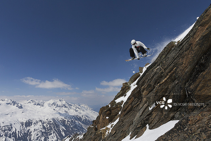 滑雪运动员在岩石斜坡上跳跃图片素材
