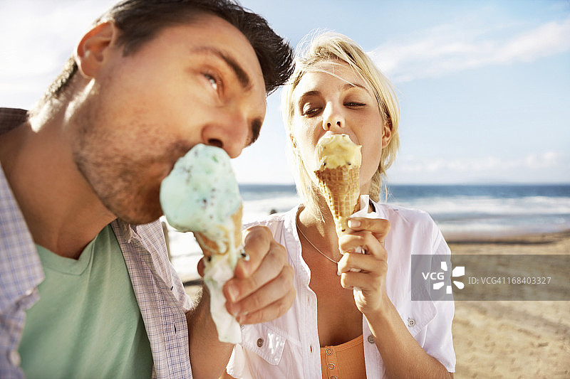 年轻夫妇在海滩上吃冰淇淋图片素材