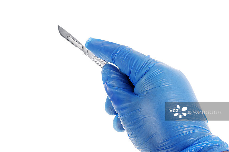手持手术刀的手在塑料外科手套里图片素材