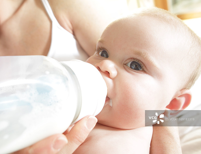 婴儿正在用奶瓶喂奶图片素材