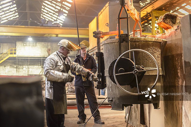 铸造厂工人准备浇注熔化金属的烧瓶图片素材