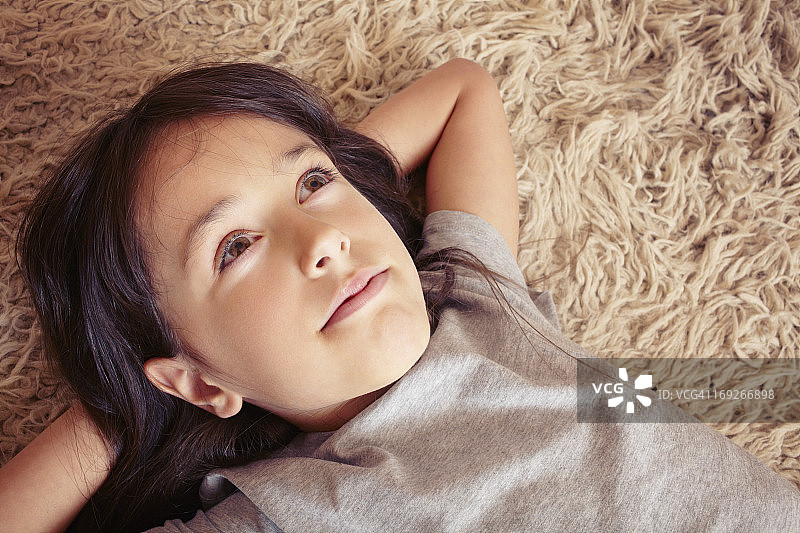 女孩躺在粗毛地毯上图片素材
