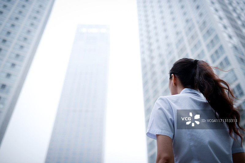 商业女人与摩天大楼办公楼背景- XXXXXLarge图片素材