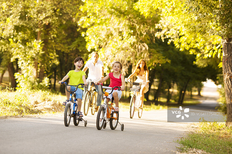 快乐家庭户外骑自行车。图片素材