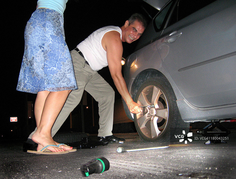 男人帮女人修车胎图片素材
