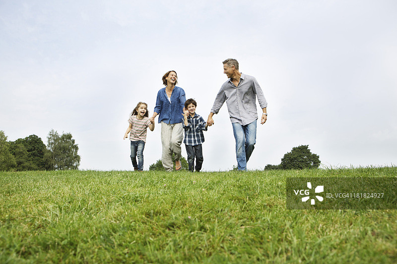 幸福的家庭漫步在草地上图片素材