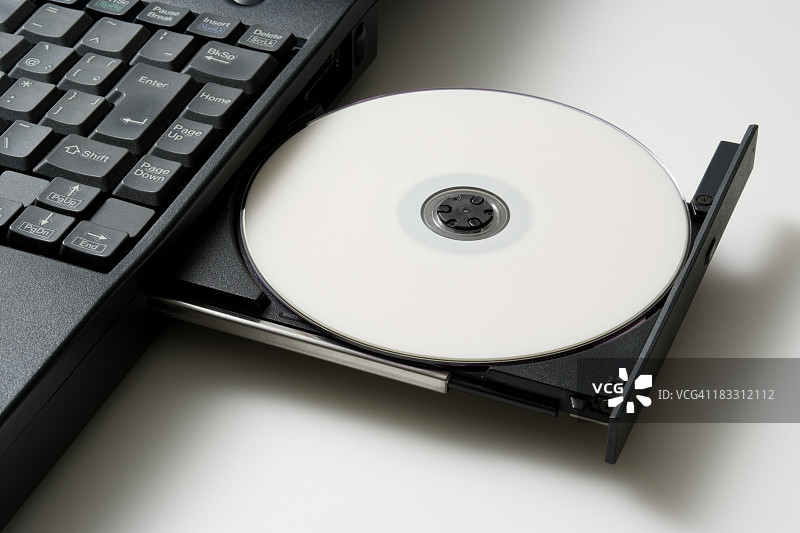 笔记本电脑与加载空白DVD驱动器的白色背景图片素材