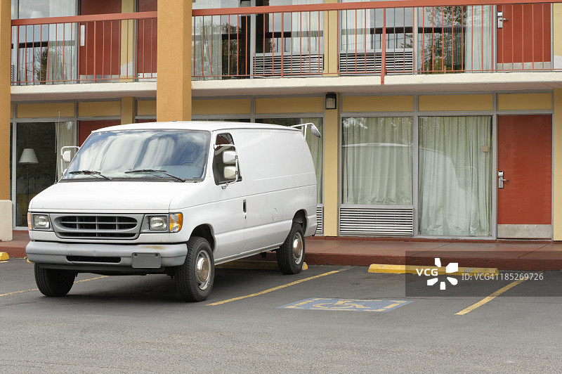 汽车旅馆的门和停放的白色面包车特写图片素材