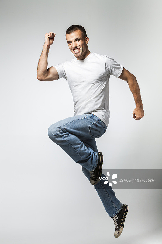 一个微笑着跳跃的年轻人的肖像图片素材